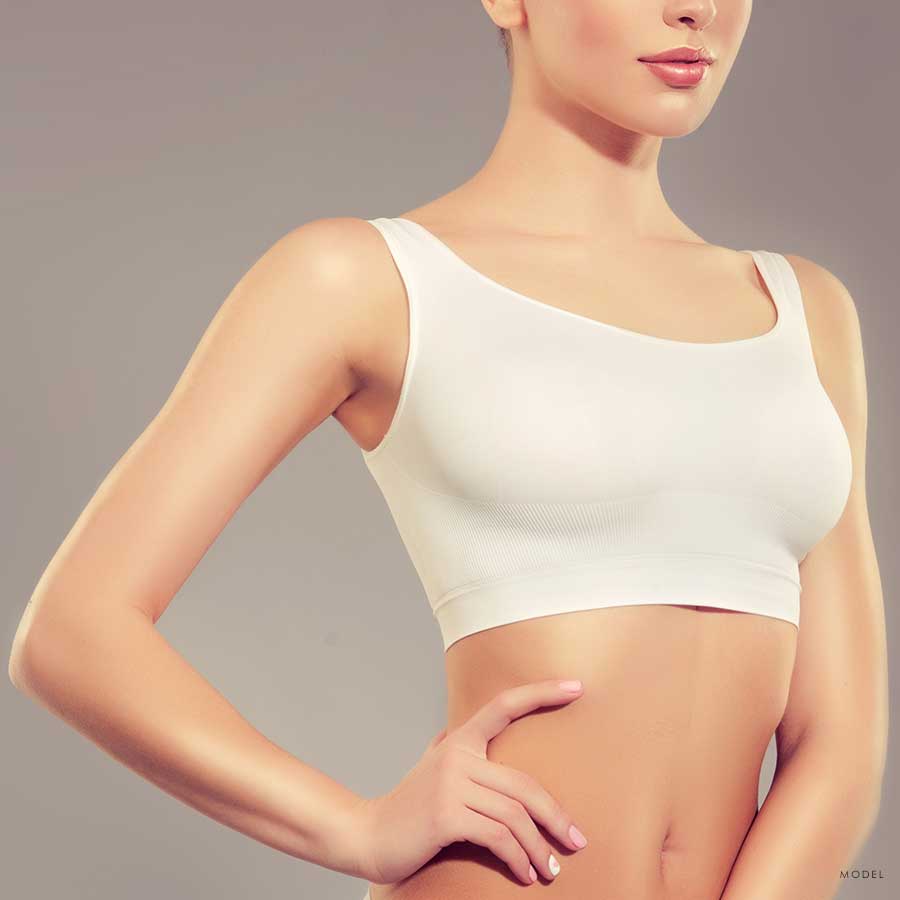 Upper body shot of a thin woman in a white sports top