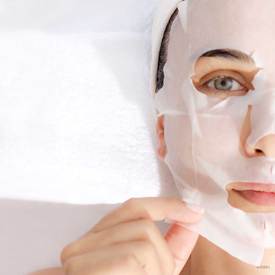 Headshot of half of a woman's face applying a face mask