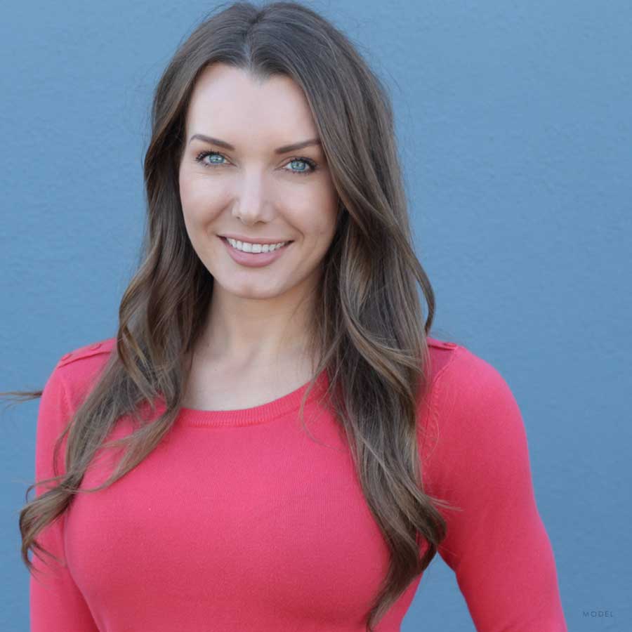 Headshot of female model smiling in a red shirt